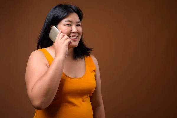 Vackra överviktiga asiatisk kvinna talar på mobiltelefon — Stockfoto
