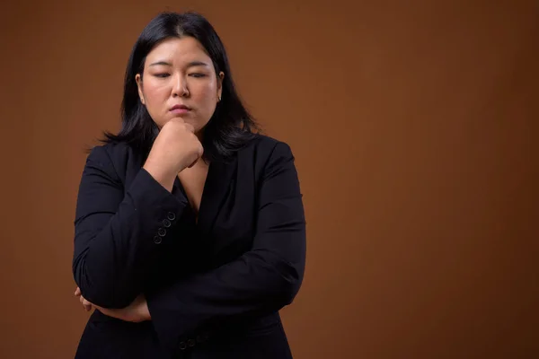 Stressato sovrappeso asiatico businesswoman pensiero e guardando giù — Foto Stock