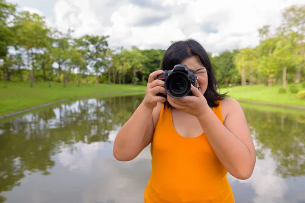 Schöne übergewichtige asiatische Fotografin Aufnahme in Park — Stockfoto