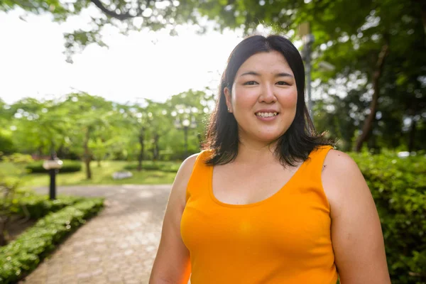 Krásná nadváhu Asijské žena s úsměvem v parku — Stock fotografie