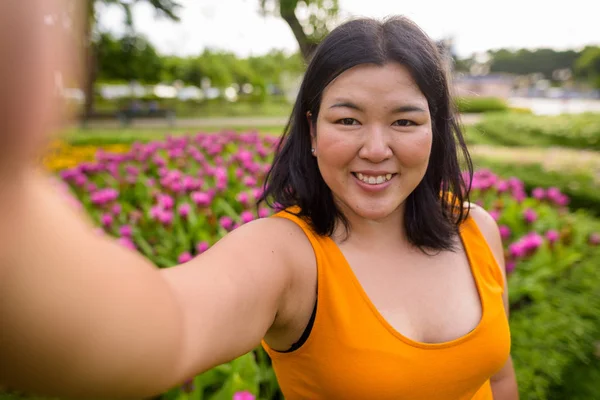 Osobní hlediska krásné obézní žena selfie v parku — Stock fotografie