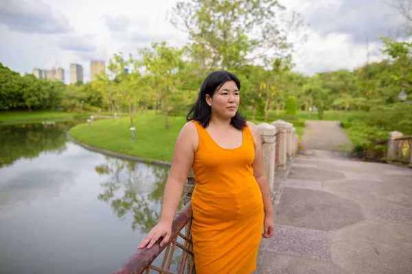 Beautiful overweight Asian woman relaxing at the park — Stock Photo, Image