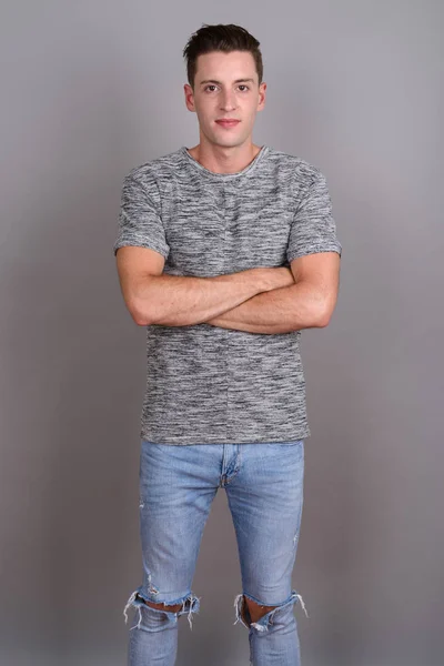 Fiatal jóképű férfi szürke inget visel szürke háttér — Stock Fotó