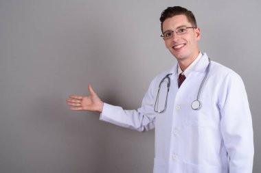 Gülümseyen ve kopya alanı gösterilen genç yakışıklı adam doktor