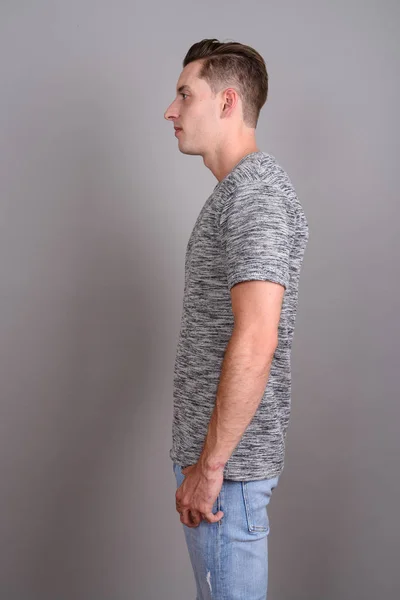 Visualização de perfil de homem bonito jovem vestindo camisa cinza — Fotografia de Stock