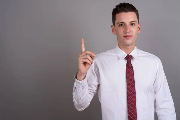 Retrato de jovem empresário bonito apontando o dedo para cima — Fotografia de Stock