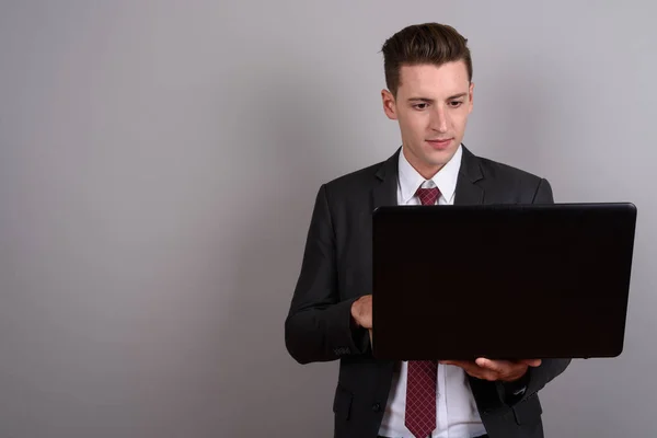Portrait of young handsome businessman using laptop computer — Stock Photo, Image