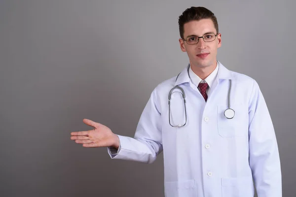 Joven hombre guapo médico mostrando espacio de copia —  Fotos de Stock