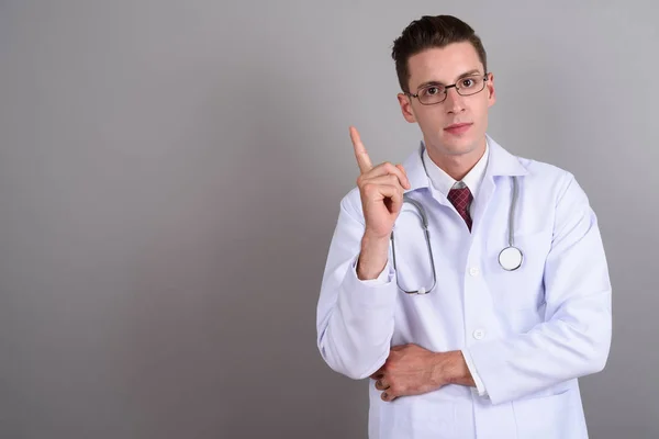Молодой привлекательный доктор показывает пальцем вверх — стоковое фото