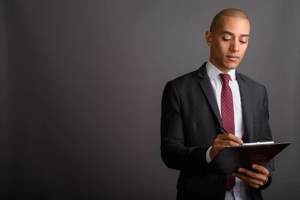 Handsome bald businessman holding clipboard and planning — Stock Photo, Image