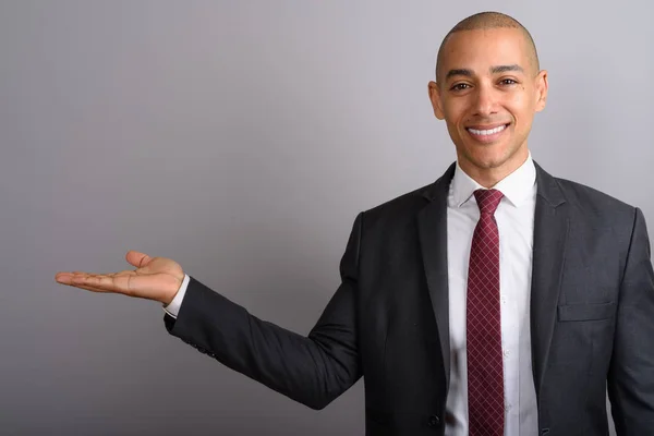 Handsome bald businessman wearing suit and showing copy space — Stock Photo, Image