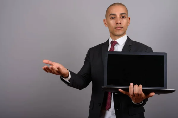 Handsome bald businessman holding laptop computer with copy space — Stock Photo, Image