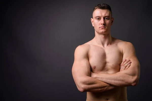 Ritratto di giovane uomo muscoloso e muscoloso senza maniche con le braccia incrociate — Foto Stock