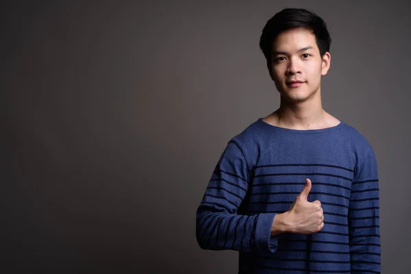 Young handsome Asian man giving thumb up — Stock Photo, Image