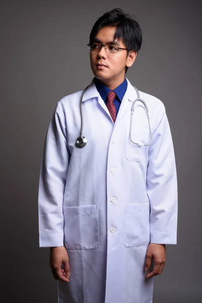 Retrato de un joven asiático médico pensando y mirando hacia arriba — Foto de Stock