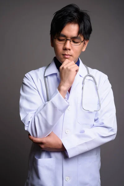 Retrato de joven serio asiático hombre médico pensando —  Fotos de Stock