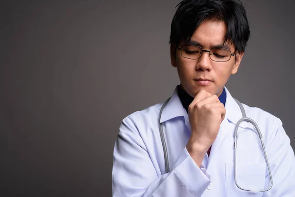 Twarz młodzieńca poważny Azjatycki lekarz myśli — Zdjęcie stockowe