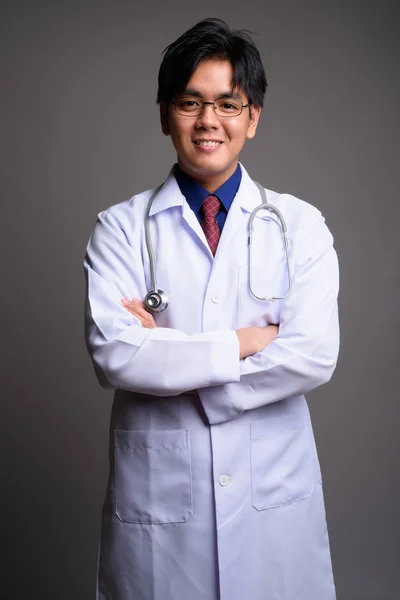 Confident young Asian man doctor smiling with arms crossed — Stock Photo, Image