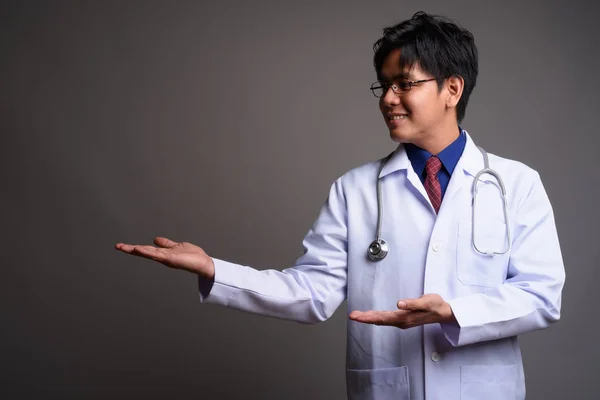 Asiático homem médico sorrindo e mostrando espaço cópia — Fotografia de Stock