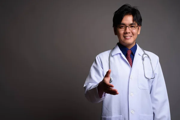 Retrato de jovem asiático feliz médico dando aperto de mão — Fotografia de Stock