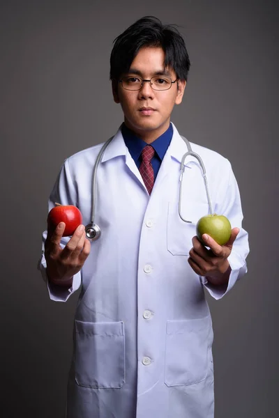Asya adam doktor tutmak sağlıklı yeşil elma ve kırmızı elma — Stok fotoğraf