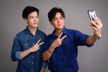 İki genç yakışıklı Asya erkek selfie ile cep telefonu alarak
