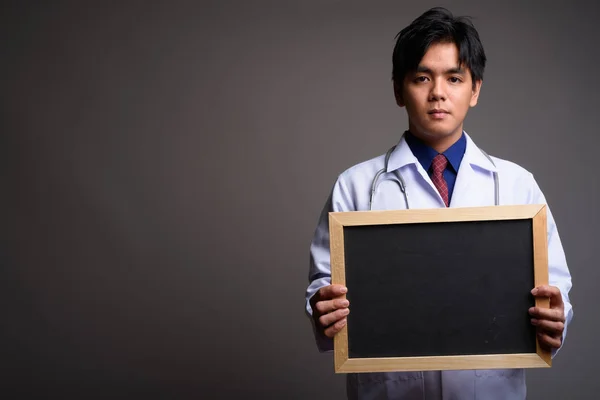 Asian man doctor holding empty blackboard with copyspace — Stock Photo, Image