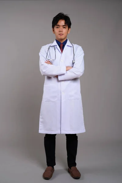 Full length portrait of young Asian man doctor with arms crossed — Stock Photo, Image