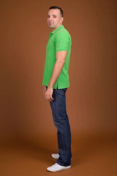 Full length shot of man standing against brown background — Stock Photo, Image