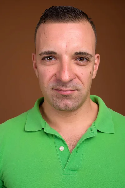 Man wearing green shirt against brown background — Stock Photo, Image