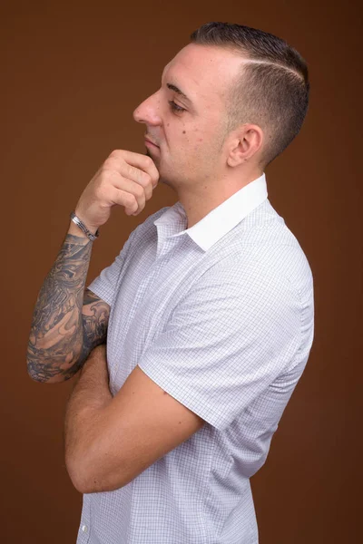 Homem vestindo camisa branca contra fundo marrom — Fotografia de Stock