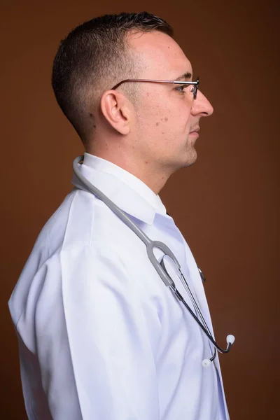 Lekarz mężczyzna noszenie okularów na brązowym tle — Zdjęcie stockowe