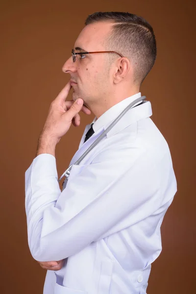 Arzt trägt Brille vor braunem Hintergrund — Stockfoto