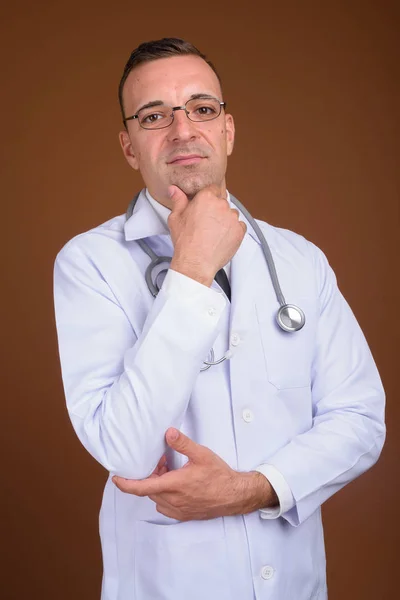 Seorang dokter memakai kacamata dengan latar belakang coklat — Stok Foto