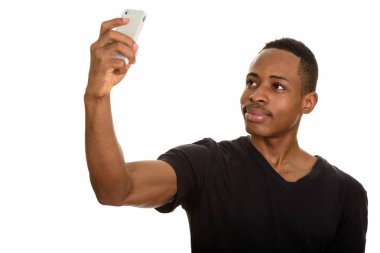 Genç Afrikalı adam cep telefonuyla selfie çekiyor.