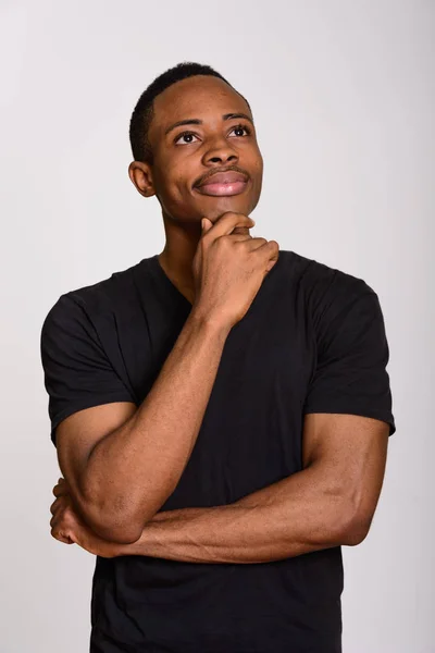 Jonge Afrikaanse man denken en holding hand op kin — Stockfoto