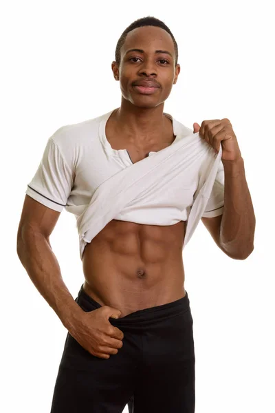 Retrato de jovem e bonito homem africano mostrando abdominais — Fotografia de Stock