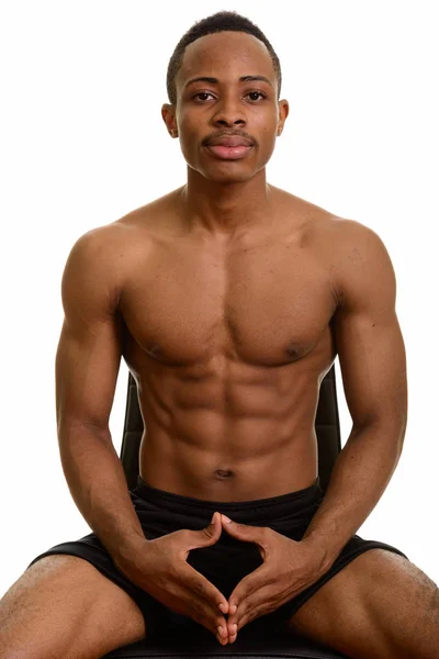 Jeune homme africain beau et musclé assis torse nu — Photo