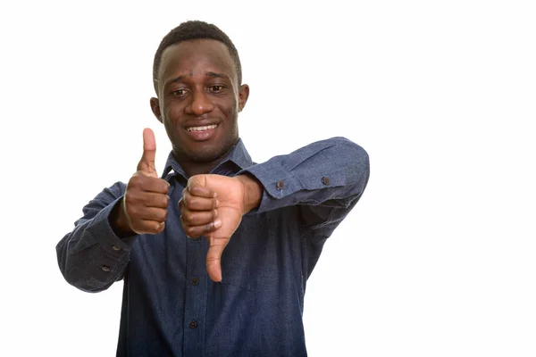 Jovem homem africano feliz sorrindo enquanto dá polegares para cima e para baixo — Fotografia de Stock