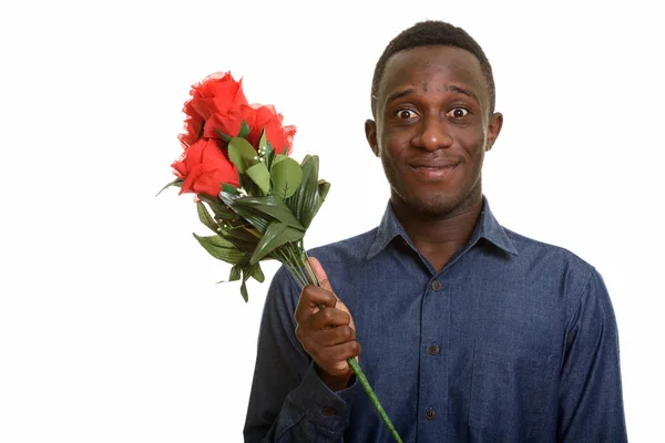 Giovane felice uomo africano sorridente e guardando eccitato mentre holdin — Foto Stock