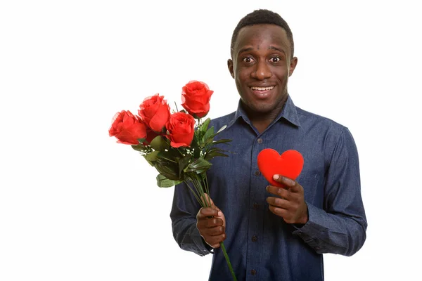 Giovane felice uomo africano sorridente mentre tiene rose rosse e rosse — Foto Stock