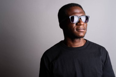 Genç Afrika dostum giyen siyah gömlek gri bir arka plana dayanır