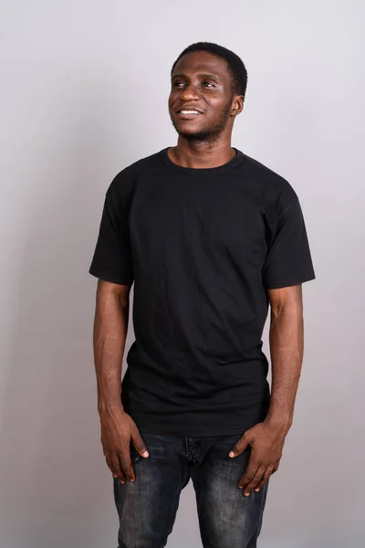 Young African man wearing black shirt against gray background — Stock Photo, Image