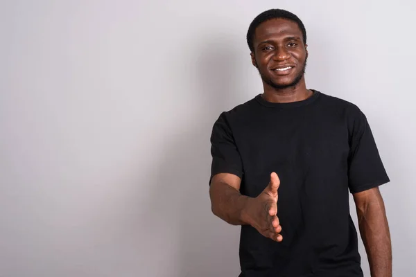 Joven hombre africano con camisa negra sobre fondo gris —  Fotos de Stock