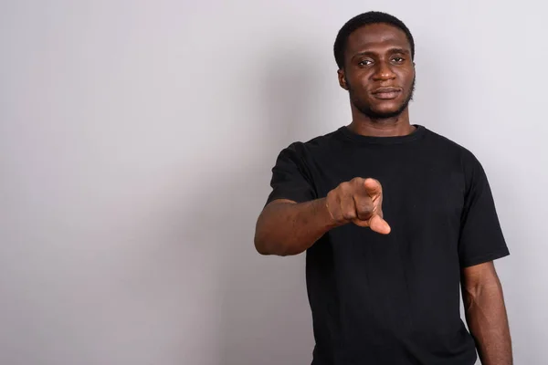 Joven hombre africano con camisa negra sobre fondo gris —  Fotos de Stock