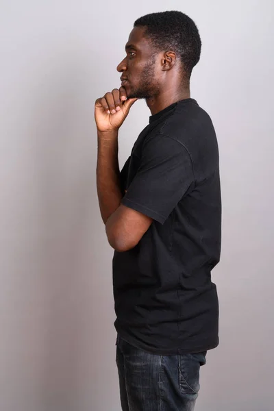 Mladí africké muž na sobě černé tričko šedé pozadí — Stock fotografie