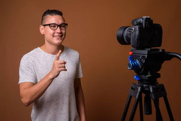 Joven guapo hombre multiétnico contra el fondo marrón — Foto de Stock