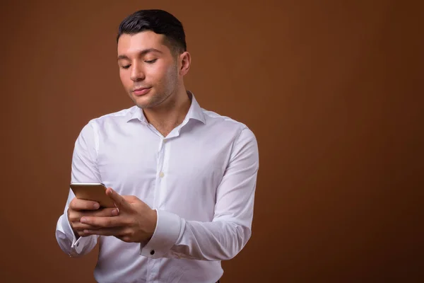 Retrato de joven hombre de negocios guapo sobre fondo marrón —  Fotos de Stock