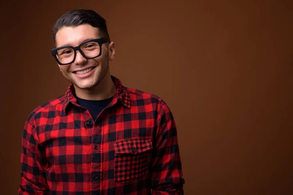 Retrato de homem bonito jovem contra fundo marrom — Fotografia de Stock