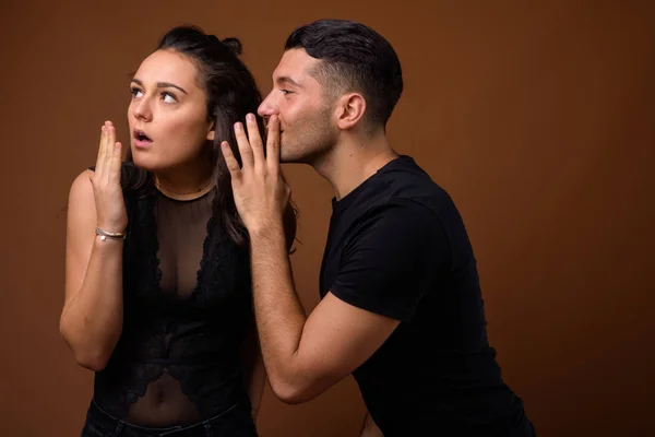 Jovem casal juntos e no amor contra fundo marrom — Fotografia de Stock